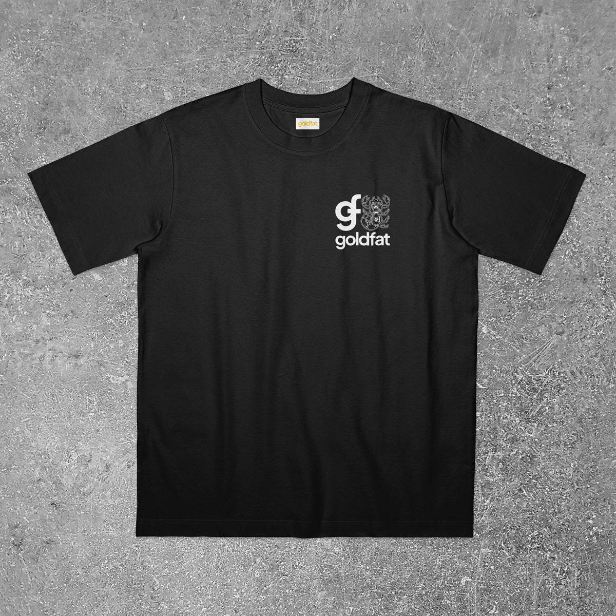 Black t-shirt with goldfat logo on a gray textured background