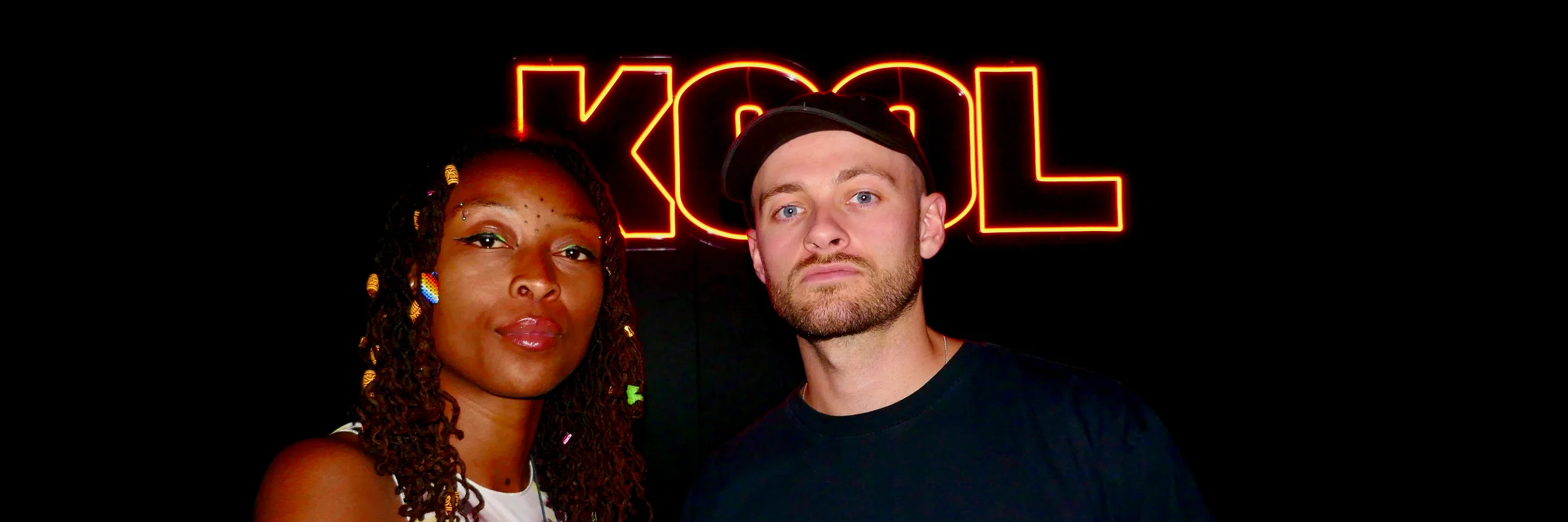 The Goldfat show hosts in front of the KOOL neon sign